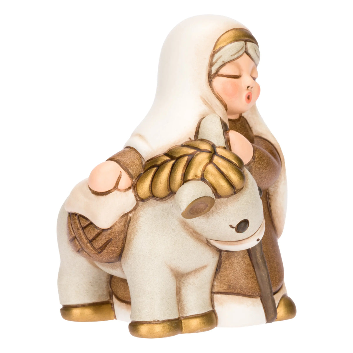 Statuina in ceramica raffigurante una donna del presepe con velo bianco e veste marrone, che accompagna un asinello con basto dorato appoggiando la mano sulla sua testa. Personaggio dal design classico e curato firmato THUN, ideale per arricchire il presepe o come idea regalo natalizia.