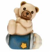 Statuina THUN in ceramica raffigurante un orsetto teddy seduto su un razzo spaziale blu con dettagli argentati e stella dorata. Decorazione dipinta a mano, ideale per la cameretta e come idea regalo.