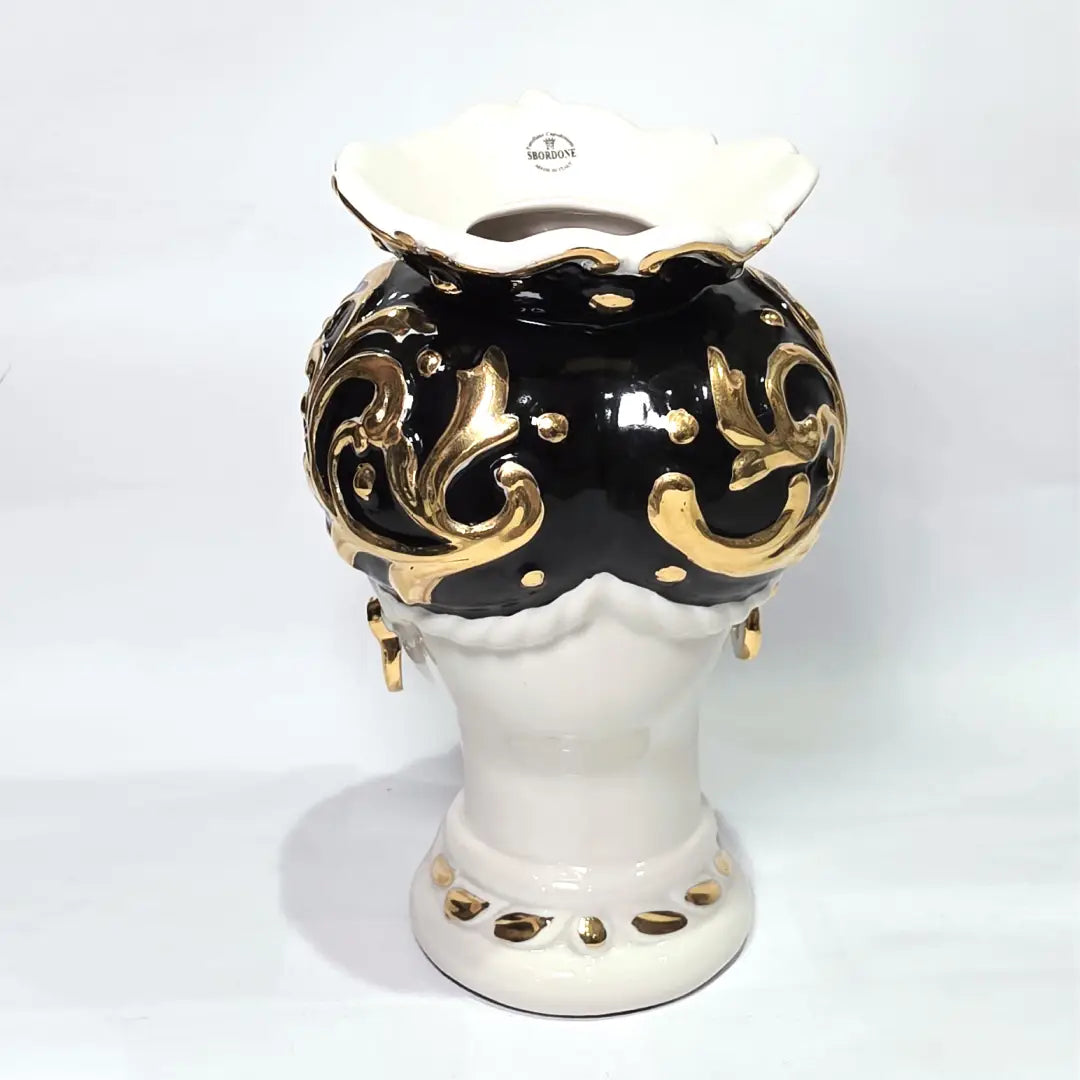 Coppia di Teste di Moro in ceramica artigianale bianca lucida con turbanti neri riccamente decorati da fregi e dettagli in oro zecchino. Queste sculture ornamentali raffiguranti un uomo con baffi e una donna con labbra dorate sono complementi d'arredo di lusso che reinterpretano la tradizione siciliana in chiave moderna ed elegante.