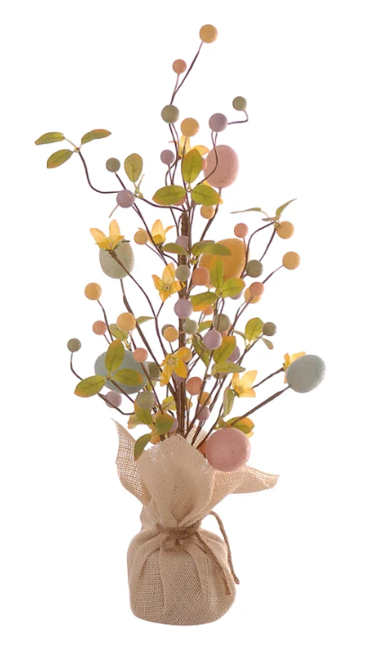Statuina decorativa a forma di alberello pasquale slanciato. La base è avvolta in un sacchetto di juta color crema con chiusura a fiocco in spago. Dai rami sottili e alti si diramano uova pastello (rosa, azzurro, giallo), foglie verdi, piccoli fiori gialli e bacche decorative. Design verticale, ideale per composizioni floreali pasquali.