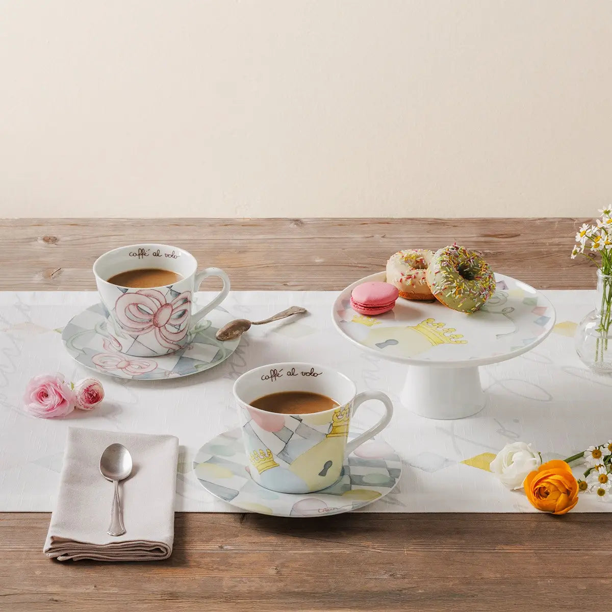 Alzata Thun "Incanto di Pasqua" inserita in un'ambientazione tavola apparecchiata, utilizzata per esporre ovetti di cioccolato e dolci pasquali. Un complemento d'arredo elegante per la sala da pranzo.