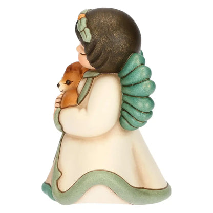 Statuina in ceramica Thun dell'Angelo della Natura Silvia, Limited Edition 2025, formato piccolo. L'angelo è raffigurato con gli occhi chiusi, ali verdi e una corona di foglie; indossa una veste color crema con bordi verdi e tiene tra le braccia, stringendolo al petto, un piccolo cerbiatto marrone. Design iconico Thun con finitura opaca e colori sfumati.