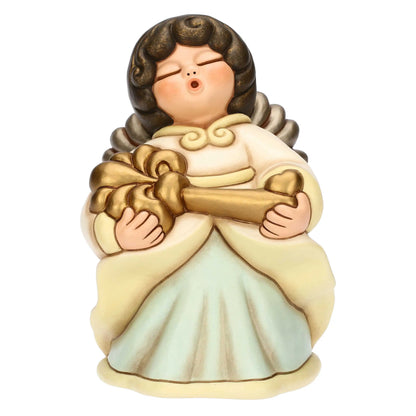 L'immagine presenta un soggetto in ceramica dallo stile armonioso e arrotondato, tipico della produzione artigianale Thun. Un Angelo cantore, raffigurato con gli occhi chiusi e la bocca aperta in un'espressione di serena devozione indossa una tunica color crema con una gonna verde acqua e tiene tra le mani una grande chiave dorata ornamentale.
