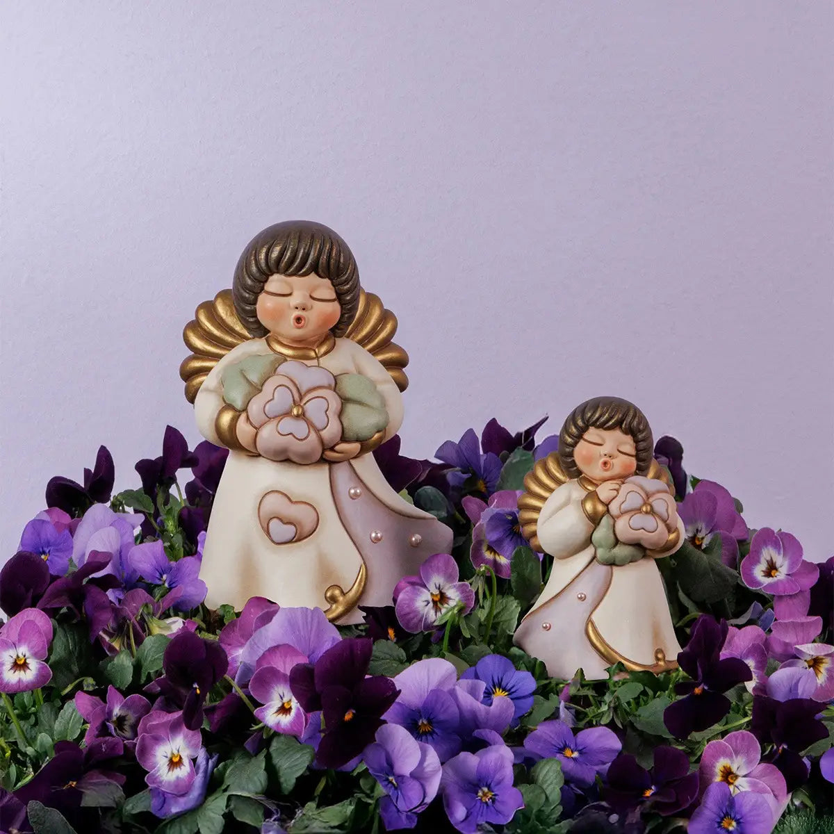 Statuina in ceramica THUN raffigurante un angelo con tunica viola che regge un fiore, edizione limitata per la Festa della Mamma.