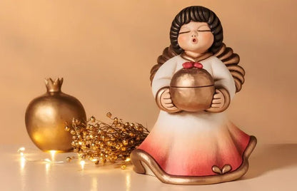 Angelo Gemma Thun Limited Edition 2025, statuina da collezione in ceramica decorata a mano. L'angelo tiene tra le mani un grande cristallo trasparente a forma di gemma, simbolo di luce e purezza per l'anno 2025.