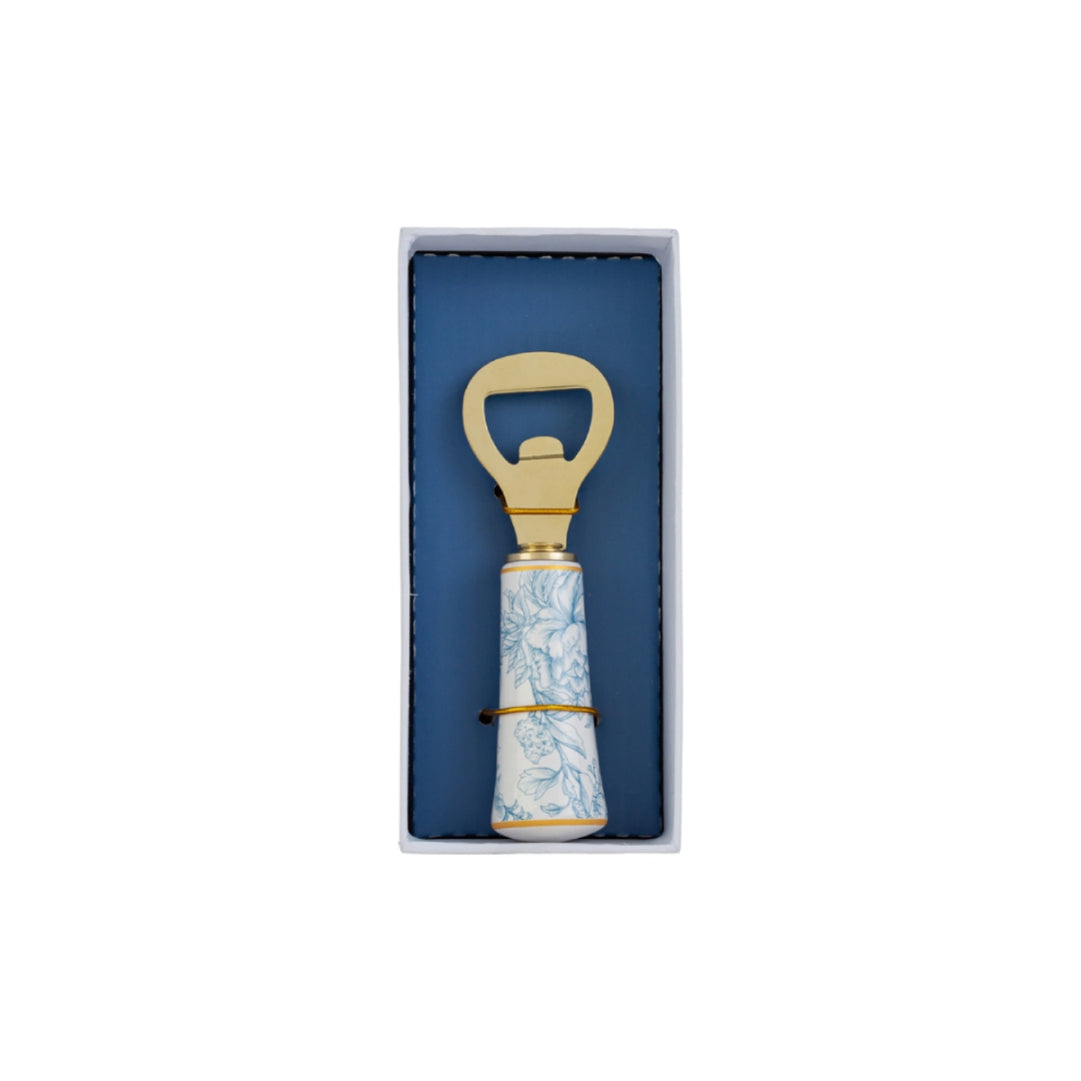 Apribottiglie con decoro azzurro firmato Le Stelle, caratterizzato da una solida testa in metallo color oro e un elegante manico in porcellana bianca decorato con delicati motivi floreali azzurri. Questo raffinato utensile da cucina e bar di design è accompagnato dalla sua custodia regalo rettangolare coordinata con la stessa fantasia botanica, perfetto come bomboniera di classe o idea regalo home decor.