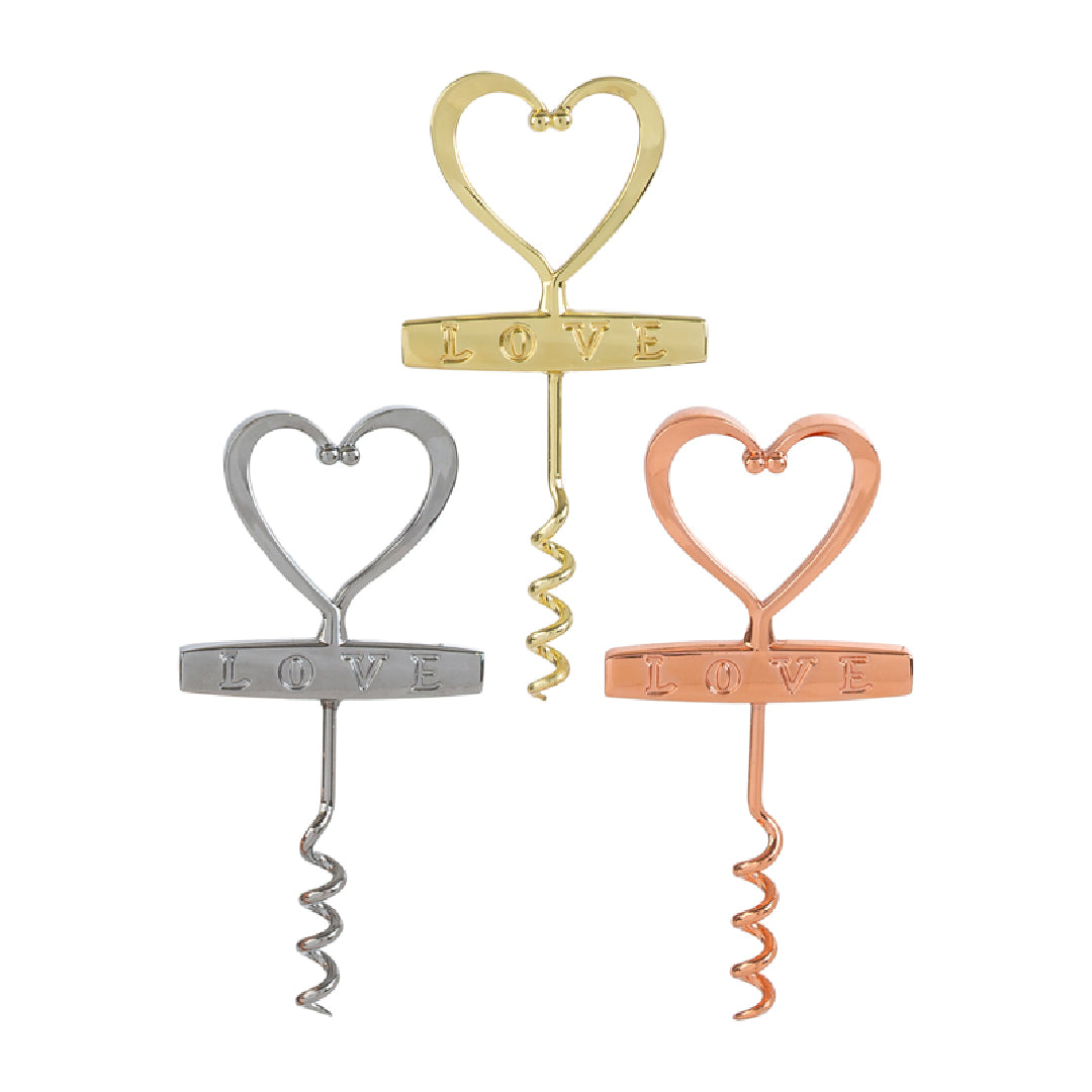 Cavatappi in metallo a forma di cuore con scritta "Love" incisa, disponibile in tre finiture assortite argento, oro e rosé, presentato accanto alla sua confezione bianca con logo "Le Stelle". Accessorio da tavola originale ideale come bomboniera o idea regalo per matrimoni ed eventi.