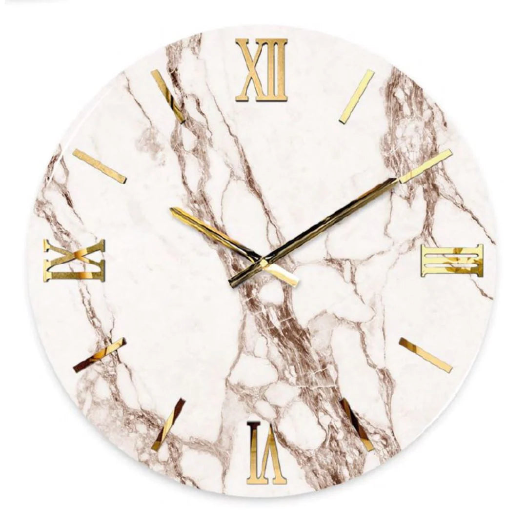 Orologio da parete circolare "Rose" di Artidea. Il quadrante presenta una raffinata texture effetto marmo bianco con venature brune e rosate. I numeri romani (XII, III, VI, IX) e gli indici lineari sono realizzati in metallo dorato lucido applicato a rilievo, coordinati con le sottili lancette dorate. Design moderno e lussuoso.