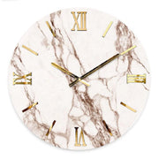Orologio da parete circolare "Rose" di Artidea. Il quadrante presenta una raffinata texture effetto marmo bianco con venature brune e rosate. I numeri romani (XII, III, VI, IX) e gli indici lineari sono realizzati in metallo dorato lucido applicato a rilievo, coordinati con le sottili lancette dorate. Design moderno e lussuoso.