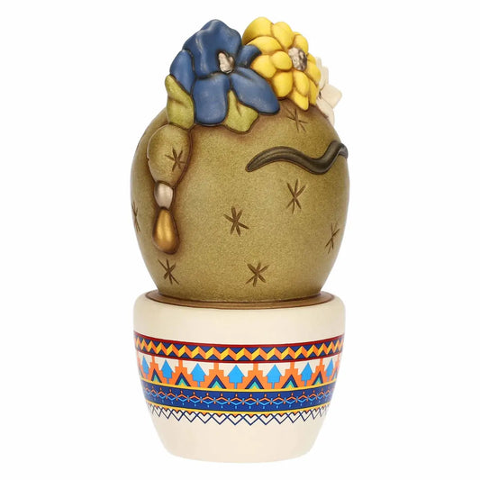 Scultura in ceramica decorativa Cactus Frida di Thun in formato medio, caratterizzata da un design ispirato a Frida Kahlo con fiori colorati sulla sommità e l'iconico sopracciglio stilizzato. Questo originale oggetto d'arredo poggia su un vasetto bianco decorato con vivaci motivi geometrici etnici, perfetto per collezionisti o come idea regalo dallo stile unico e gioioso.