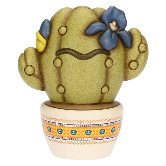 Scultura decorativa Cactus Frida di Thun in formato piccolo, realizzata in ceramica artigianale e impreziosita da fiori blu e gialli con l'iconico sopracciglio ispirato all'artista messicana. Questa statuina da collezione poggia su un vasetto bianco decorato con delicate trame etniche arancioni e blu, rappresentando un complemento d'arredo perfetto per regalare un tocco di colore e personalità agli spazi di casa.