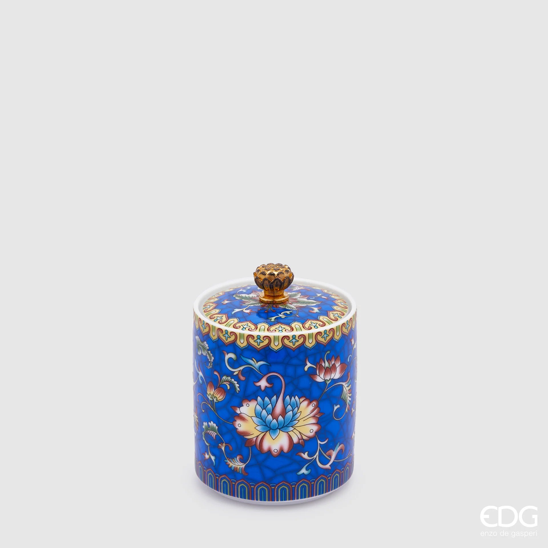La Candela Profumata in Ceramica "Ming" Blu EDG – Black Cedar è un raffinato oggetto di design racchiuso in un contenitore di ceramica decorato con ricchi motivi floreali d'ispirazione orientale su fondo blu cobalto, completato da un coperchio coordinato con pomolo dorato. Accompagnata dalla sua scatola regalo finemente illustrata, questa candela diffonde l'intensa e misteriosa fragranza "Black Cedar", rendendola un complemento d'arredo esclusivo ed elegante.