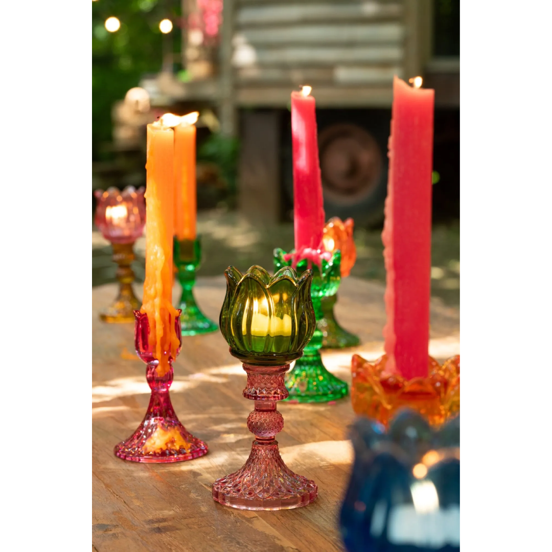 Candelabri alti a forma di tulipano in vetro mix colorato assortiti, caratterizzati da una sommità a bocciolo lavorata a costine e da uno stelo decorativo con base svasata impreziosita da una trama diamantata a rilievo. Disponibili in tre vivaci combinazioni di colore bicolore con calici blu, rosa e verde abbinati a basi arancioni, ambra e rosa sfumate, questi eleganti portacandele di design sono ideali per completare l'home decor con un tocco originale e sofisticato.