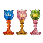 Candelabri alti a forma di tulipano in vetro mix colorato assortiti, caratterizzati da una sommità a bocciolo lavorata a costine e da uno stelo decorativo con base svasata impreziosita da una trama diamantata a rilievo. Disponibili in tre vivaci combinazioni di colore bicolore con calici blu, rosa e verde abbinati a basi arancioni, ambra e rosa sfumate, questi eleganti portacandele di design sono ideali per completare l'home decor con un tocco originale e sofisticato.