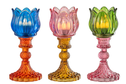 Candelabri alti a forma di tulipano in vetro mix colorato assortiti, caratterizzati da una sommità a bocciolo lavorata a costine e da uno stelo decorativo con base svasata impreziosita da una trama diamantata a rilievo. Disponibili in tre vivaci combinazioni di colore bicolore con calici blu, rosa e verde abbinati a basi arancioni, ambra e rosa sfumate, questi eleganti portacandele di design sono ideali per completare l'home decor con un tocco originale e sofisticato.