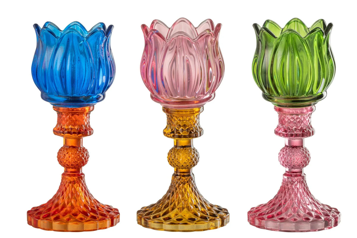 Candelabri alti a forma di tulipano in vetro mix colorato assortiti, caratterizzati da una sommità a bocciolo lavorata a costine e da uno stelo decorativo con base svasata impreziosita da una trama diamantata a rilievo. Disponibili in tre vivaci combinazioni di colore bicolore con calici blu, rosa e verde abbinati a basi arancioni, ambra e rosa sfumate, questi eleganti portacandele di design sono ideali per completare l'home decor con un tocco originale e sofisticato.