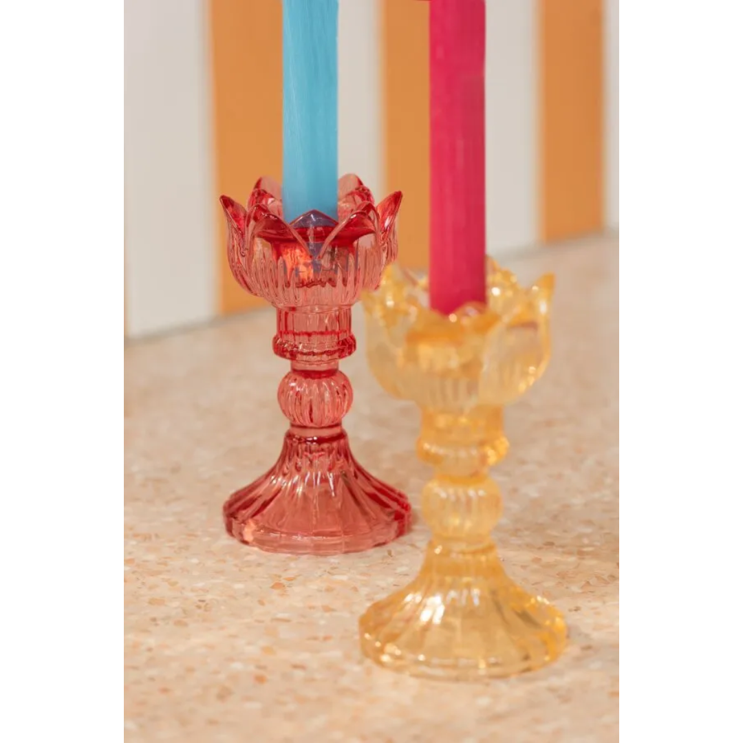 Portacandele a forma di tulipano in vetro colorato assortiti, caratterizzati da una sommità modellata a petali aperti e uno stelo decorativo scanalato che termina su una base conica lavorata a rilievo. Disponibili nelle tre varianti trasparente rosa, crema e rosso, questi eleganti candelabri di design sono ideali per sorreggere candele a stelo lungo, arricchire la tavola e donare un tocco di luce raffinato e primaverile all'home decor.