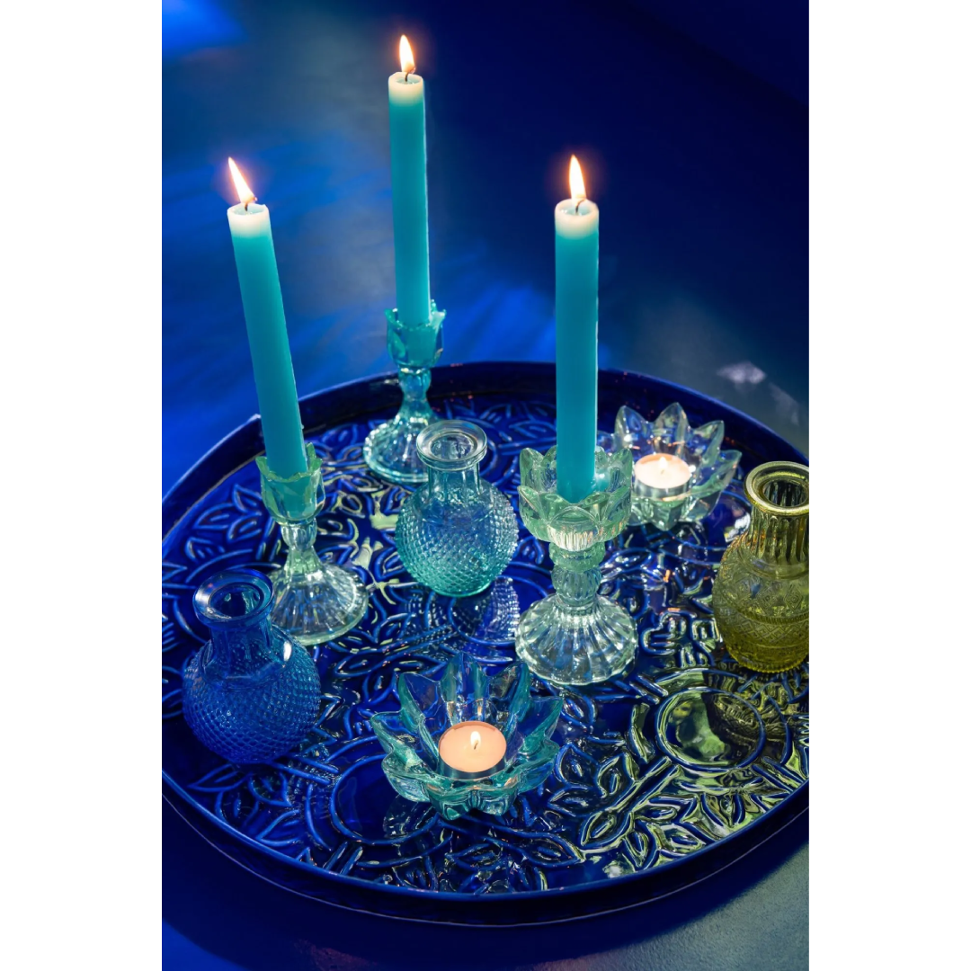 Portacandele a forma di tulipano in vetro colorato assortiti, caratterizzati da una sommità modellata a petali aperti e uno stelo decorativo scanalato che termina su una base conica lavorata a rilievo. Disponibili nelle tre varianti trasparente azzurro, biancoe verde, questi eleganti candelabri di design sono ideali per sorreggere candele a stelo lungo, arricchire la tavola e donare un tocco di luce raffinato e primaverile all'home decor.