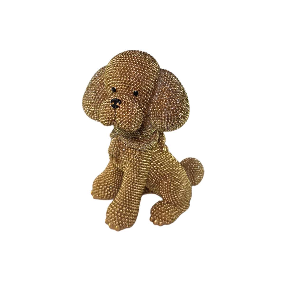Statuina in resina raffigurante un cagnolino dorato seduto con lunghe orecchie pendenti e una sciarpa arrotolata al collo, interamente ricoperto di brillantini glitterati, con occhi e naso neri. Oggetto decorativo scintillante firmato Sud Import, ideale come soprammobile per bambini o idea regalo per gli amanti degli animali.
