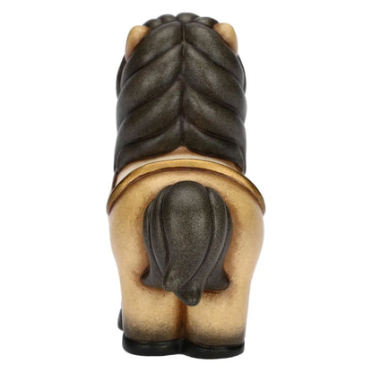 Statuina in ceramica del cavallo Isabella di piccole dimensioni firmata THUN, caratterizzata da un corpo nei toni caldi del beige con criniera, coda e zoccoli scuri sfumati. La figura da collezione presenta forme dolci e arrotondate tipiche del marchio, arricchita da una sella color panna con dettagli dorati sul dorso che la rende un'ottima idea regalo o un elemento decorativo per la casa.