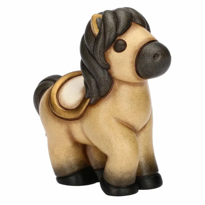 Statuina in ceramica del cavallo Isabella di piccole dimensioni firmata THUN, caratterizzata da un corpo nei toni caldi del beige con criniera, coda e zoccoli scuri sfumati. La figura da collezione presenta forme dolci e arrotondate tipiche del marchio, arricchita da una sella color panna con dettagli dorati sul dorso che la rende un'ottima idea regalo o un elemento decorativo per la casa.