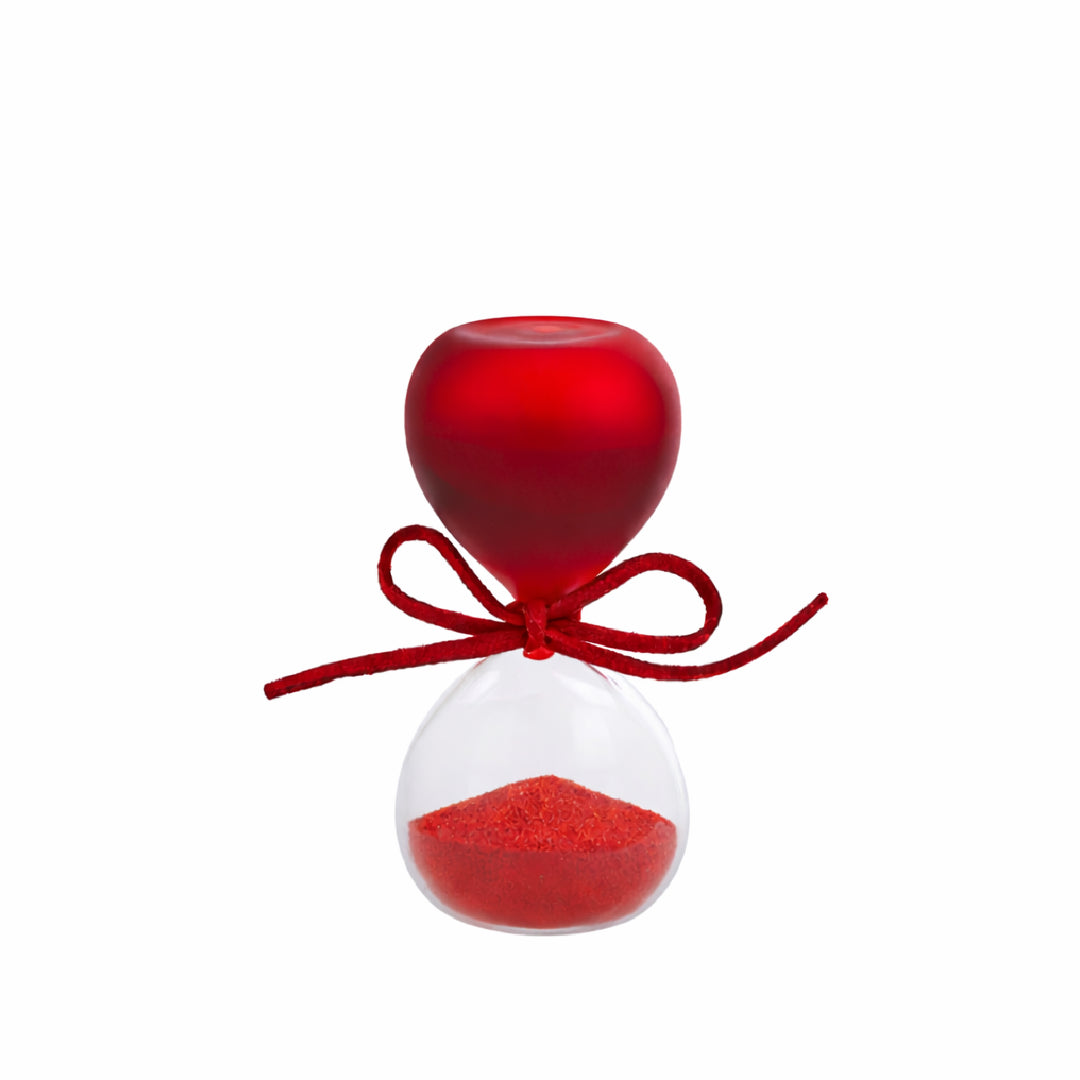 Clessidra in vetro satinato rosso a forma di clava, con base conica trasparente riempita di sabbia rossa e cordoncino con etichetta tonda "Le Stelle" decorata da un cappello di laurea. Oggetto decorativo elegante presentato con la sua confezione bianca del marchio, ideale come bomboniera per lauree o idea regalo raffinata.
