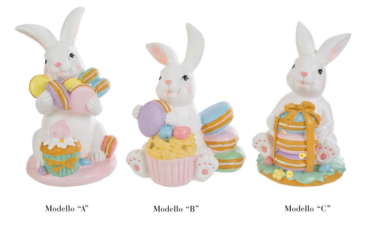 Tris di statuine pasquali assortite del marchio Le Stelle (codice 12244) raffiguranti coniglietti bianchi con dolci e pasticcini. Il Modello A tiene dei macaron e ha un cupcake alla base; il Modello B è seduto accanto a una pila di macaron e un grande pasticcino; il Modello C tiene una torre di macaron legata con un fiocco dorato. Decorazioni in resina dai colori pastello.