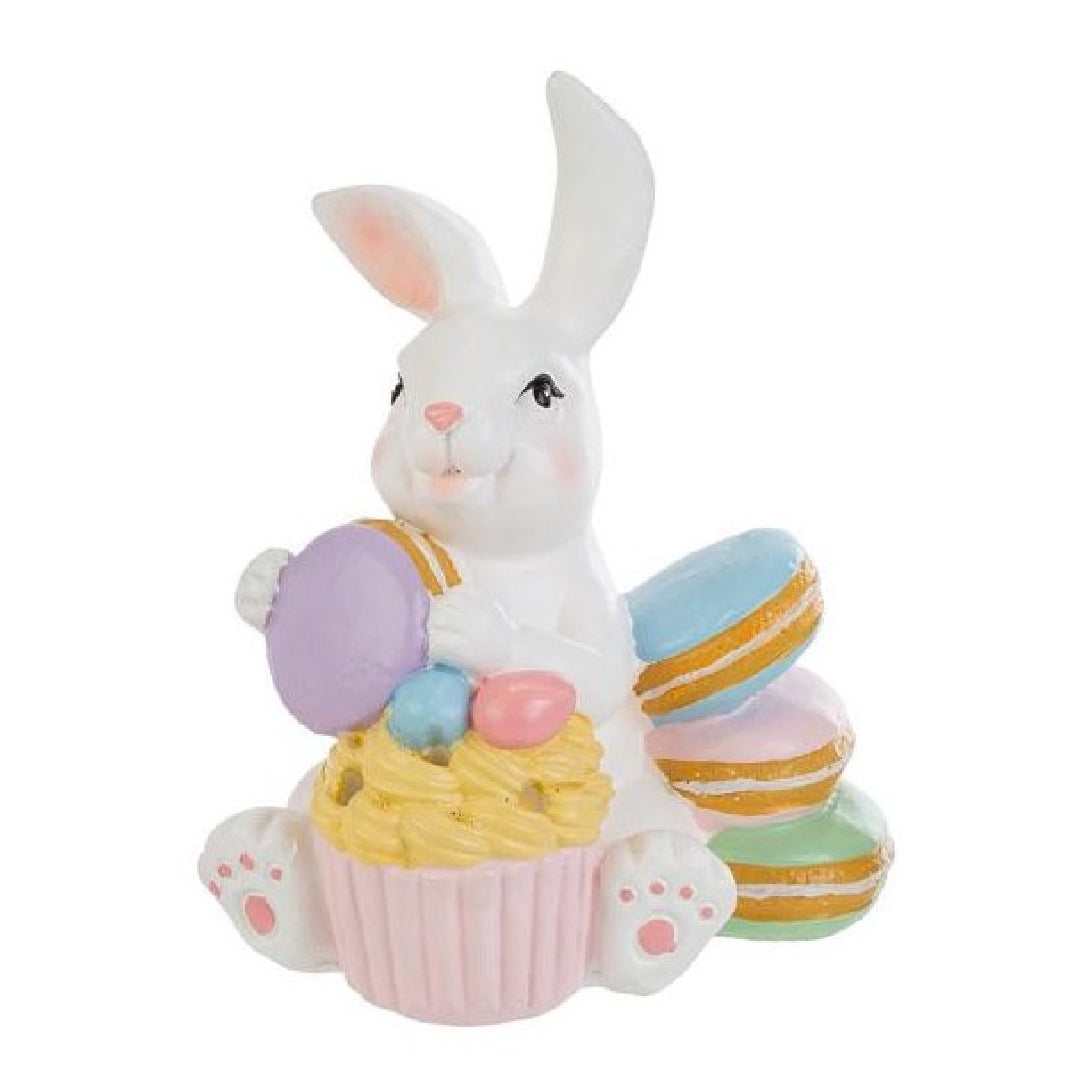 Tris di statuine pasquali assortite del marchio Le Stelle (codice 12244) raffiguranti coniglietti bianchi con dolci e pasticcini. Il Modello A tiene dei macaron e ha un cupcake alla base; il Modello B è seduto accanto a una pila di macaron e un grande pasticcino; il Modello C tiene una torre di macaron legata con un fiocco dorato. Decorazioni in resina dai colori pastello.