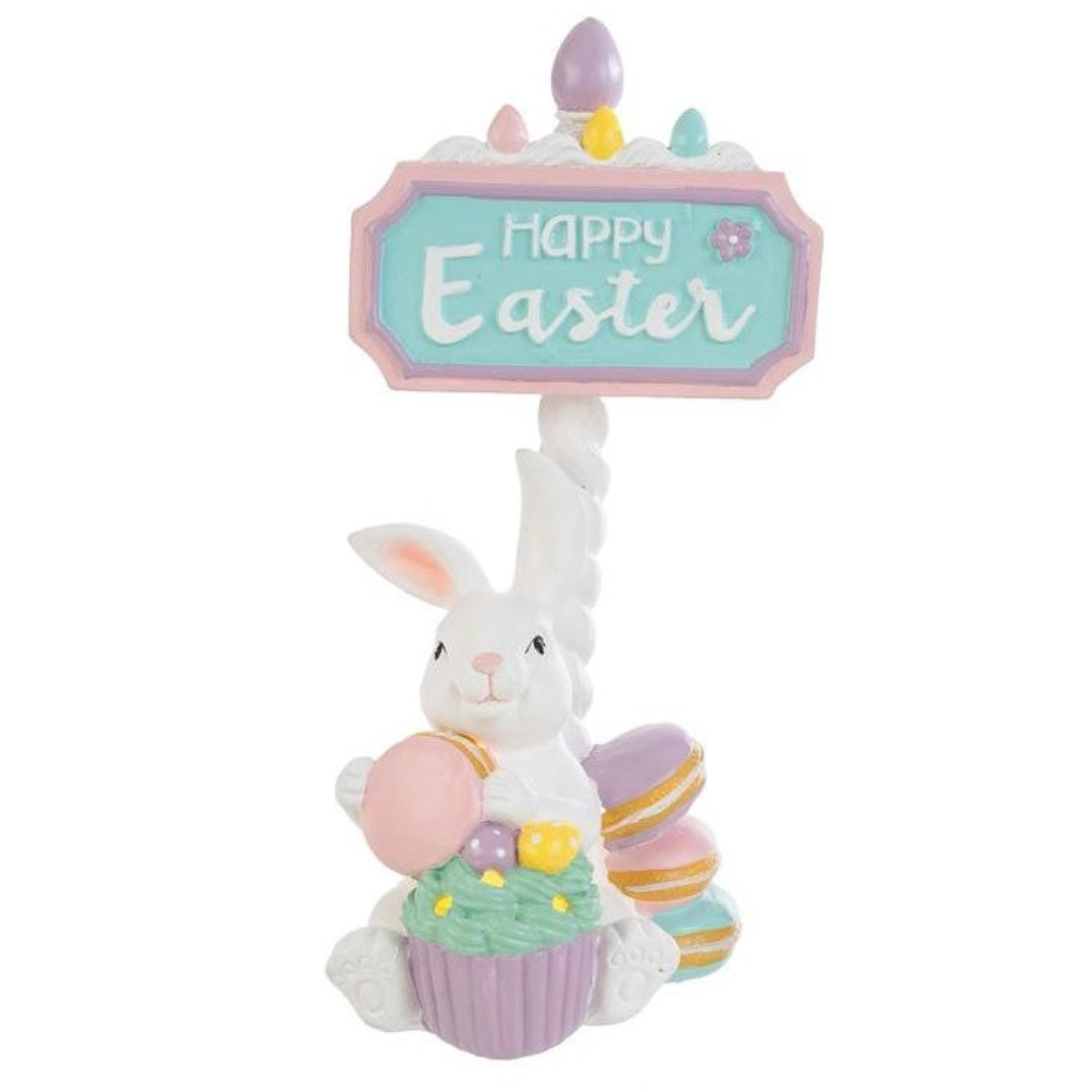 Tris di statuine pasquali assortite del marchio Le Stelle (codice 12245) raffiguranti coniglietti bianchi con dolci e pasticcini, davanti delle targhe "Happy Easter". Il Modello A tiene dei macaron e ha un cupcake alla base; il Modello B è seduto accanto a una pila di macaron e un grande pasticcino; il Modello C tiene una torre di macaron legata con un fiocco dorato. Decorazioni in resina dai colori pastello.