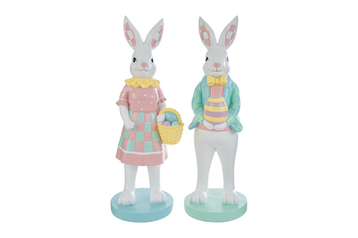 Coppia di statuine decorative a forma di conigli bianchi in piedi su basi circolari color pastello. La coniglietta indossa un abito rosa a pois con gonna a scacchi verdi e tiene un cestino di uova; il coniglio indossa una giacca a scacchi azzurri e verdi con papillon giallo e regge un uovo decorato. Design in stile MacKenzie-Childs per il marchio Le Stelle.