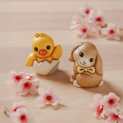 Statuina in ceramica Thun raffigurante il coniglio Roger della collezione Incanto di Pasqua. Il coniglietto, nei classici toni del marrone sfumato, è ritratto seduto con un fiocco giallo al collo e grandi occhi dolci. Iconica decorazione pasquale Thun con finitura opaca e forme morbide.