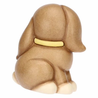 Statuina in ceramica Thun raffigurante il coniglio Roger della collezione Incanto di Pasqua. Il coniglietto, nei classici toni del marrone sfumato, è ritratto seduto con un fiocco giallo al collo e grandi occhi dolci. Iconica decorazione pasquale Thun con finitura opaca e forme morbide.