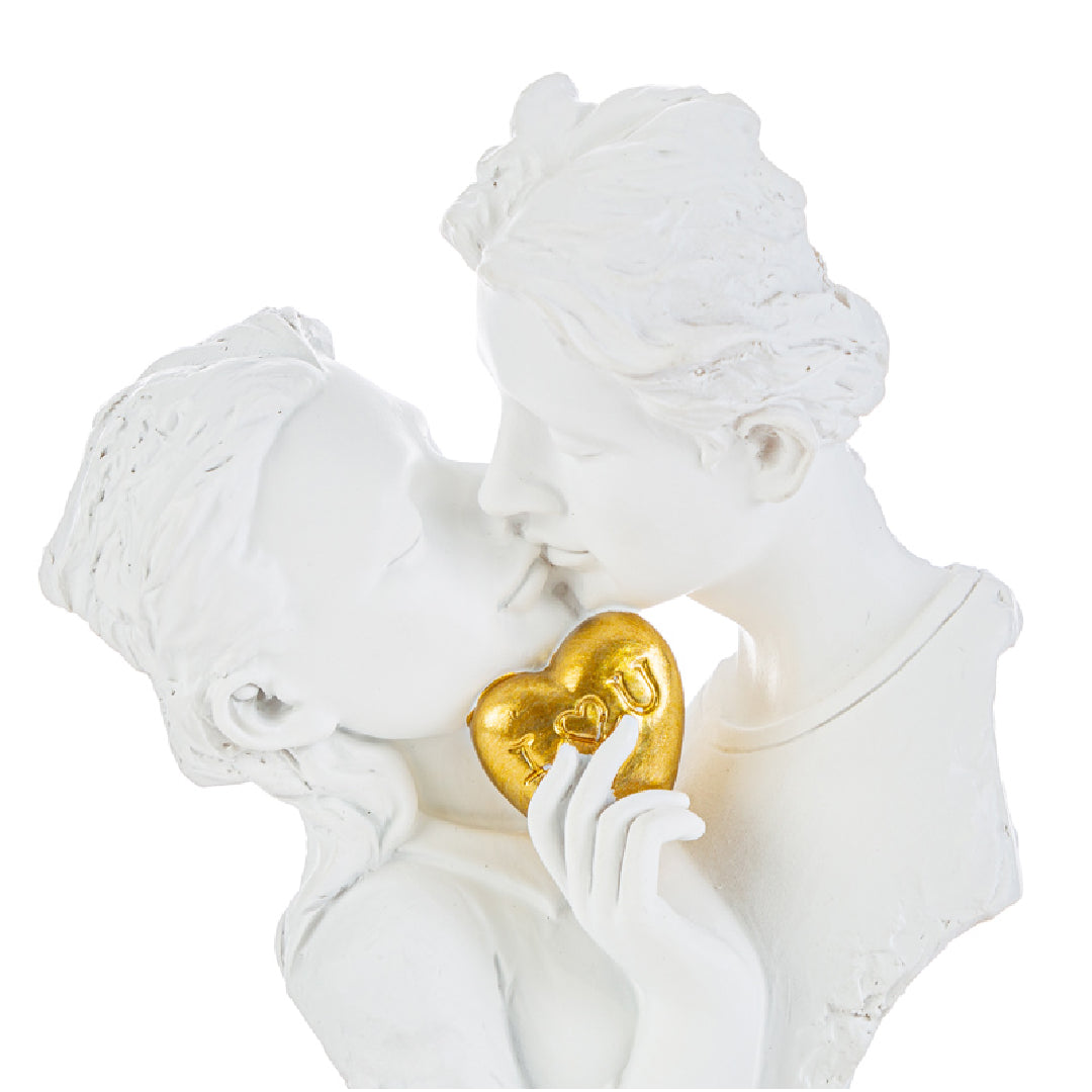 Statuina in resina bianca raffigurante una coppia di innamorati che si baciano tenendo tra le mani un cuore dorato con scritta "I love you", presentata accanto alla sua sacchetto regalo bianco con logo "Le Stelle Bomboniere". Scultura elegante ideale come bomboniera per matrimoni o anniversari, con confezione firmata pronta per il regalo.