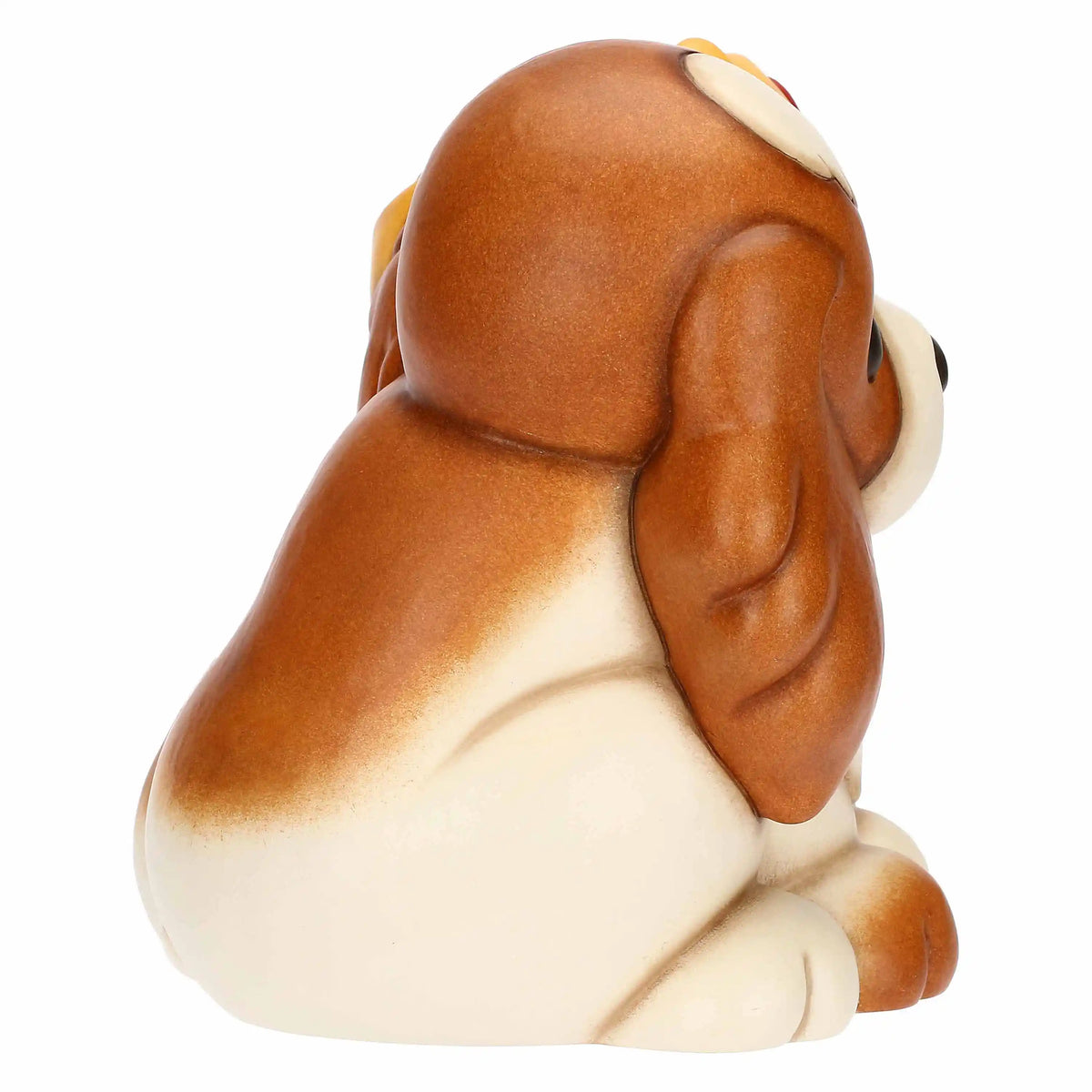 Vista laterale sinistra che mette in risalto il profilo del cane senza corona e la finitura lucida della ceramica decorata.