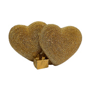 Statuina in resina raffigurante due cuori dorati affiancati, interamente ricoperti di brillantini glitterati, con un piccolo pacco regalo dorato liscio incastonato alla base. Oggetto decorativo firmato Sud Import, ideale come soprammobile romantico o idea regalo per San Valentino e occasioni speciali.