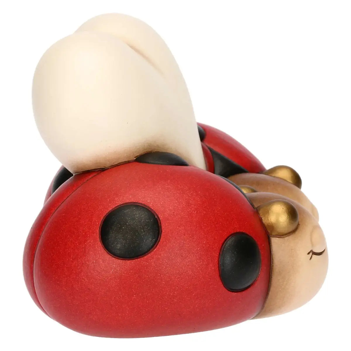 Statuina in ceramica della linea THUN raffigurante una coppia di coccinelle con guscio rosso a pois neri che si scambiano un bacio affettuoso. Le due figure da collezione, caratterizzate dai classici occhi chiusi, tengono un grande cuore color panna alle loro spalle, rendendo questo oggetto perfetto come idea regalo romantica o bomboniera.