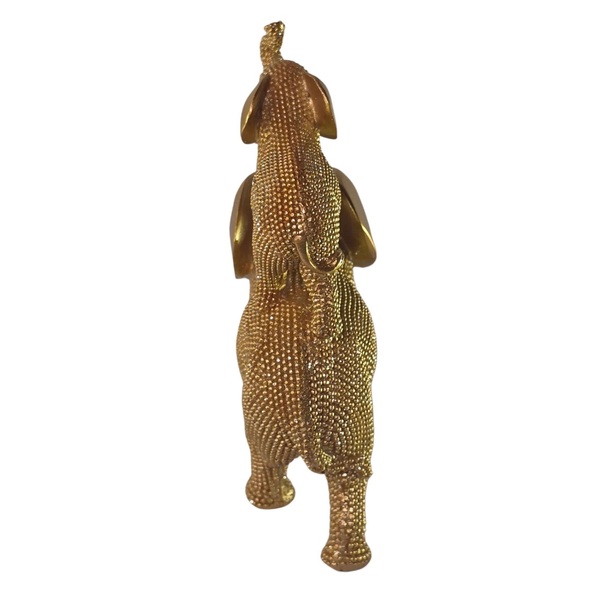 Statuina in resina raffigurante due elefanti dorati sovrapposti in composizione dinamica, con proboscide arrotolata verso l'alto e orecchie lisce a effetto metallico, interamente ricoperti di brillantini glitterati. Oggetto decorativo scintillante firmato Sud Import, ideale come soprammobile portafortuna o idea regalo per la casa.