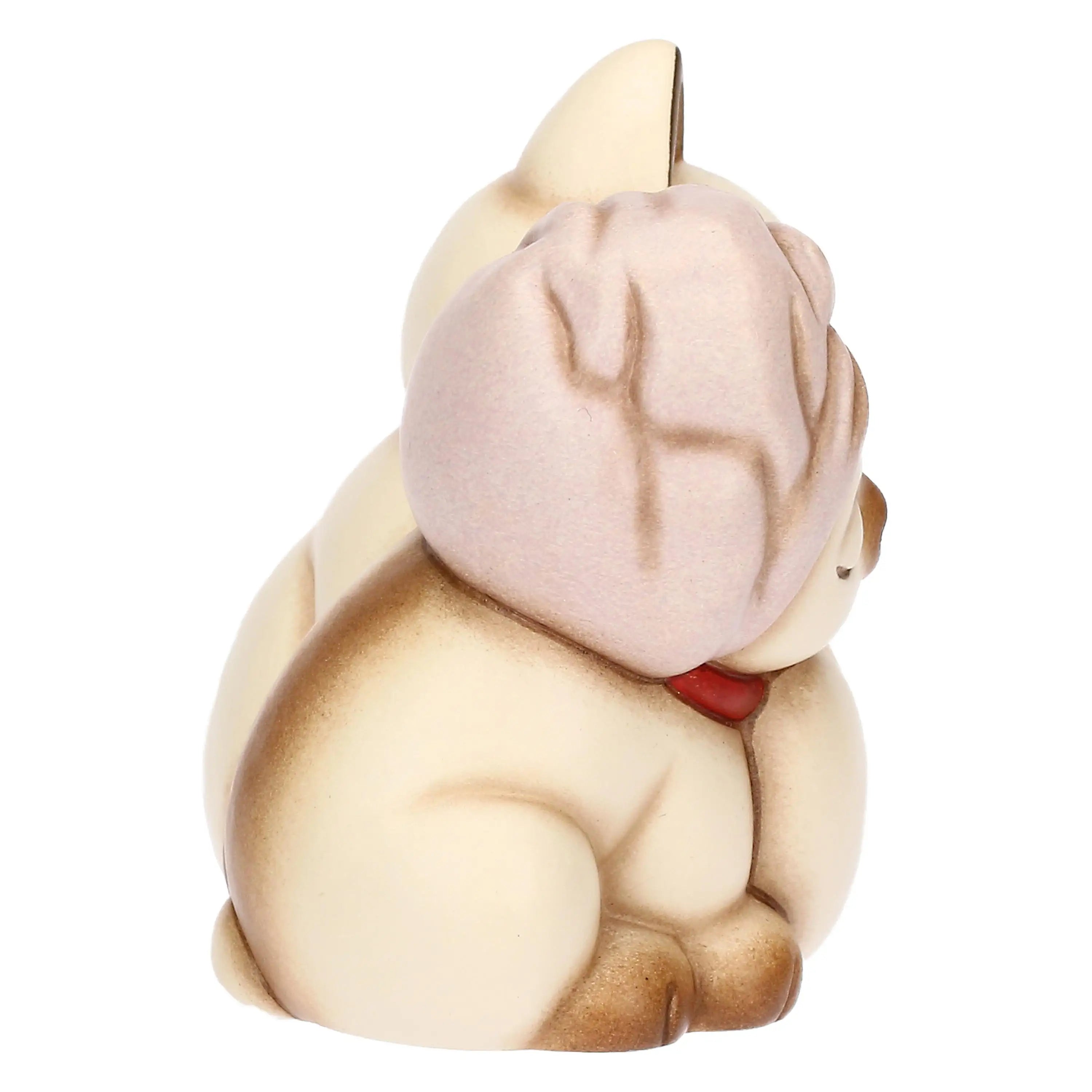L'immagine cattura la profondità della scultura in ceramica, focalizzandosi sul lato del gattino che indossa il copricapo.