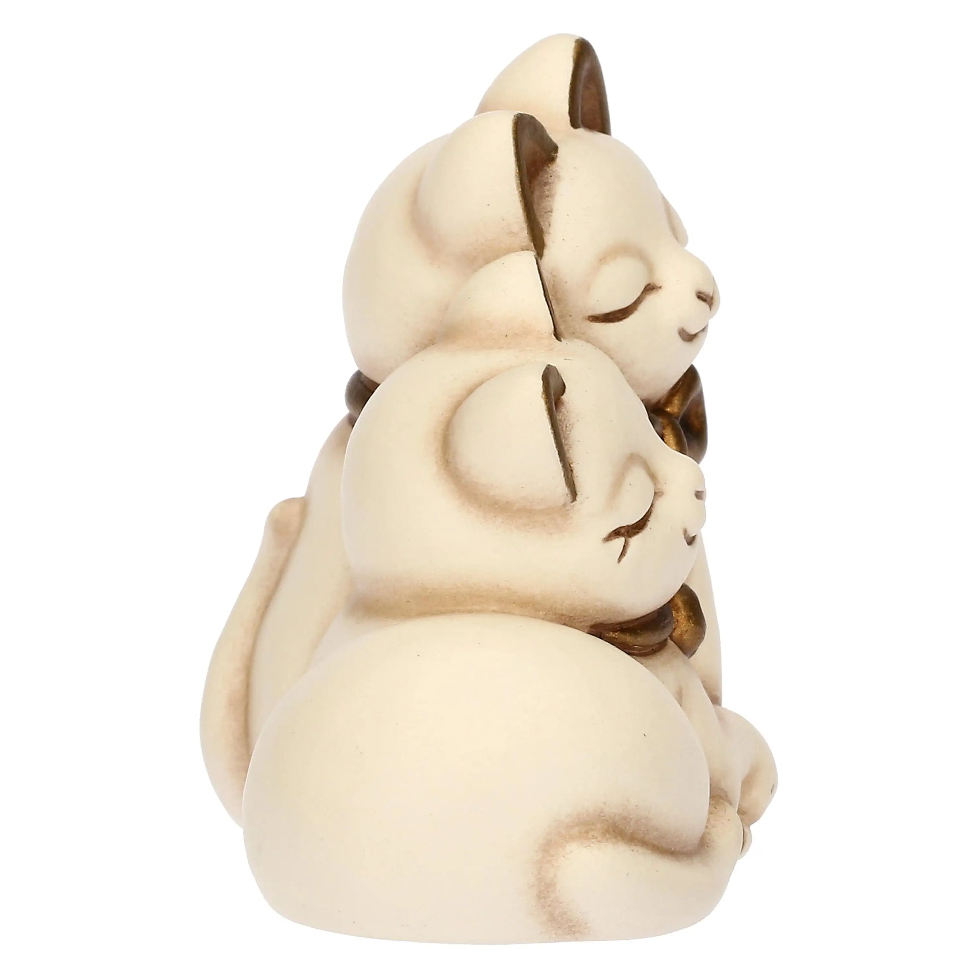 L'inquadratura laterale mette in risalto la profondità della scultura e la curvatura delle schiene dei due gattini, evidenziando il gioco di volumi della ceramica.