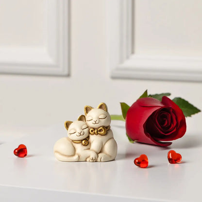 L'immagine ritrae la statuetta dei gattini sorridenti inserita in un contesto romantico e minimalista, perfetta per illustrare un'idea regalo o un complemento d'arredo per occasioni speciali.