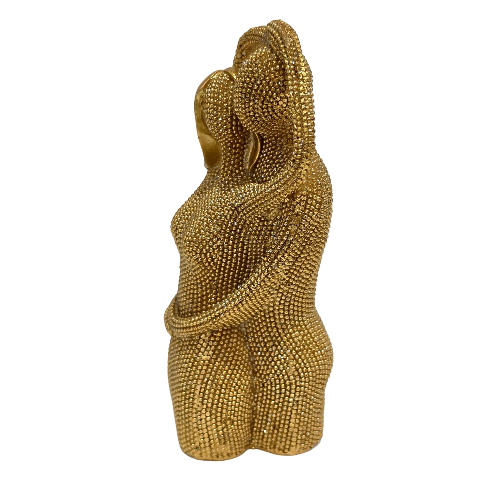 Statuina in resina raffigurante una coppia di innamorati abbracciati, con teste stilizzate lisce e corpi interamente ricoperti di brillantini glitterati dall'effetto scintillante. Oggetto decorativo firmato Sud Import, ideale come soprammobile romantico o idea regalo per San Valentino e anniversari.