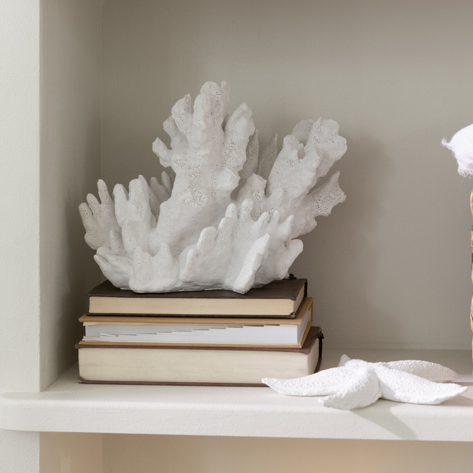 Scultura decorativa in resina a forma di corallo bianco di grandi dimensioni della collezione "Oceano Azul", caratterizzata da una struttura ramificata ricca di dettagli e ramificazioni realistiche. Questo soprammobile d'ispirazione marina presenta una superficie porosa dall'aspetto naturale, ideale come elegante elemento d'arredo per completare ambienti in stile costiero o moderno.