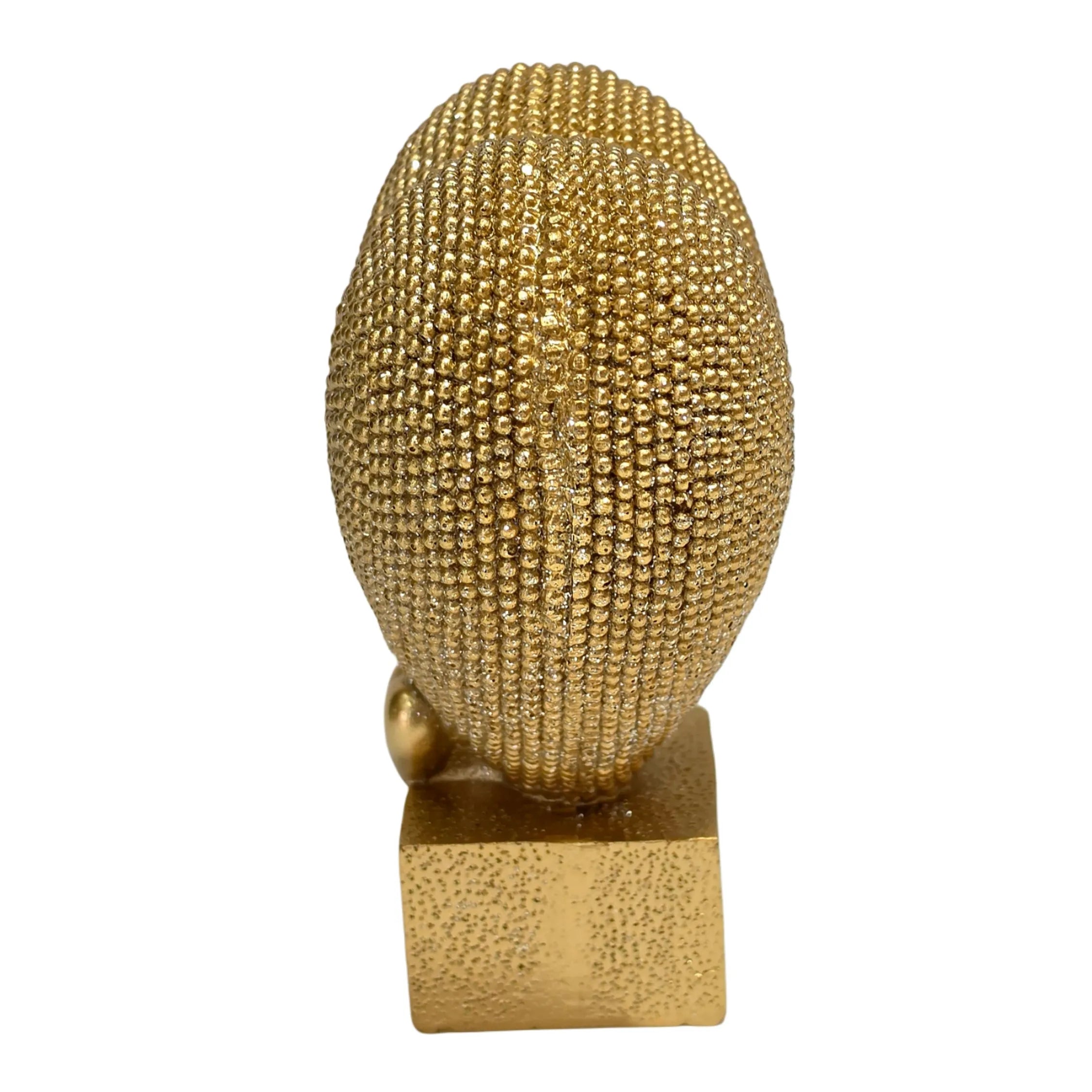 Statuina in resina raffigurante un grande cuore dorato ricoperto di brillantini glitterati, poggiante su un piccolo cuore liscio e una base cubica dorata satinata. Oggetto decorativo firmato Sud Import, ideale come soprammobile romantico o idea regalo per San Valentino e occasioni speciali.