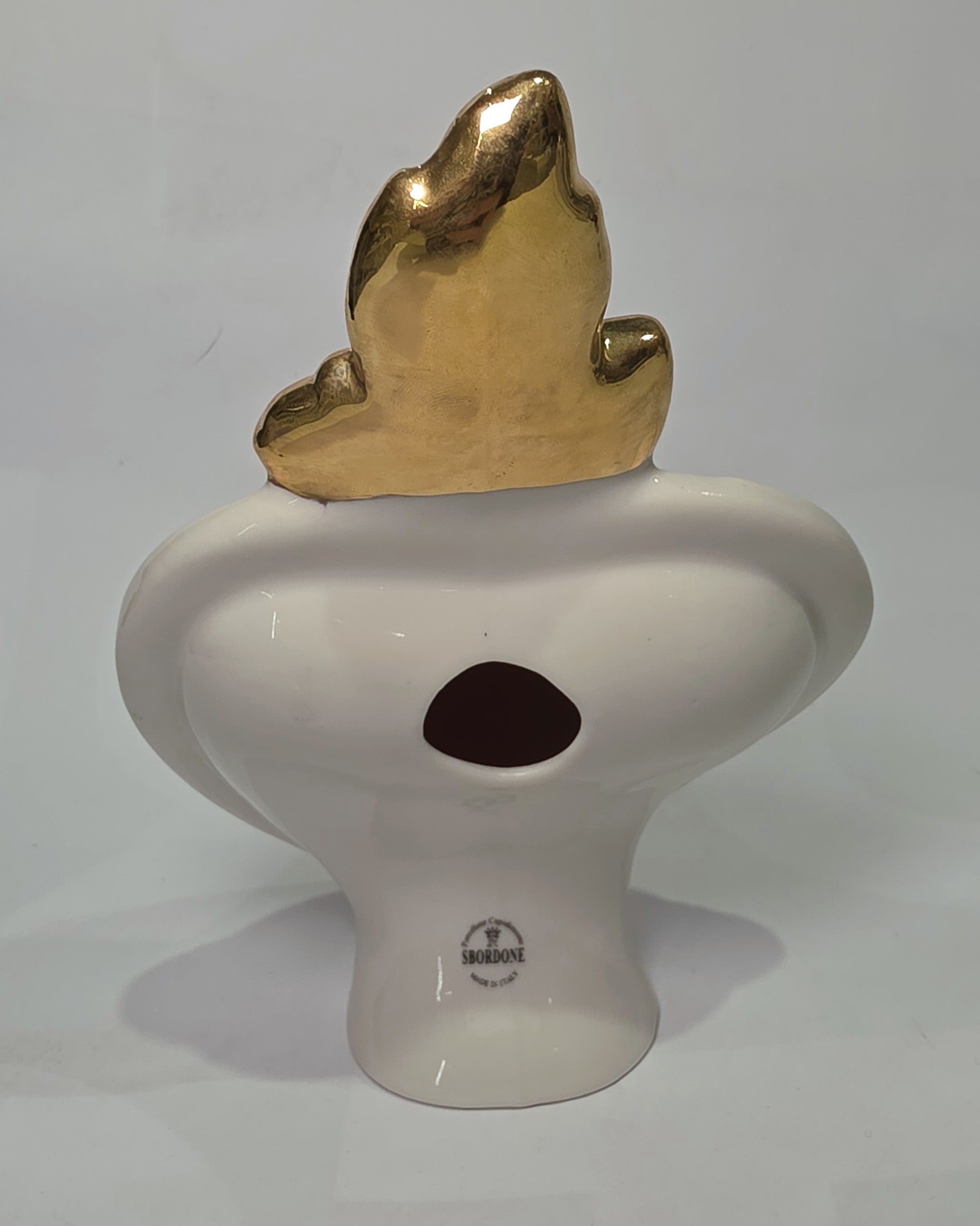 Scultura decorativa a forma di Cuore Sacro in ceramica rossa lucida, arricchita da loghi fashion bianchi e una fiamma superiore dorata. Il design è completato da una cornice bianca perlinata con borchie oro, rendendo questo oggetto un complemento d'arredo pop art unico e di tendenza per la casa.