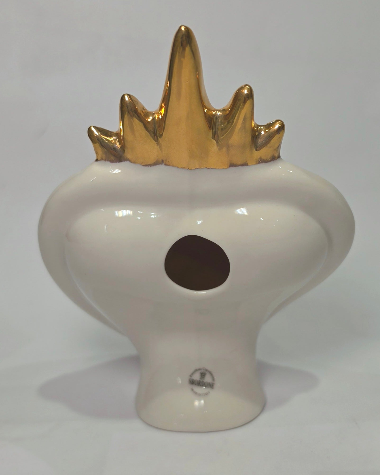 Scultura decorativa a forma di Cuore Sacro in ceramica rossa e bianca lucida, caratterizzata da un design a strisce orizzontali con le scritte "Mom" e "Dad" in corsivo nero. L'oggetto è completato da una corona superiore dorata e una cornice perlinata con dettagli gialli e borchie oro, rappresentando un complemento d'arredo affettivo e originale per la casa.