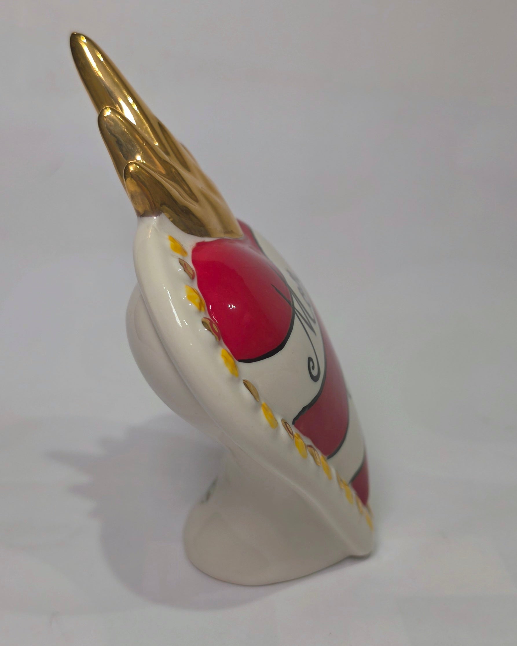 Scultura decorativa a forma di Cuore Sacro in ceramica rossa e bianca lucida, caratterizzata da un design a strisce orizzontali con le scritte "Mom" e "Dad" in corsivo nero. L'oggetto è completato da una corona superiore dorata e una cornice perlinata con dettagli gialli e borchie oro, rappresentando un complemento d'arredo affettivo e originale per la casa.