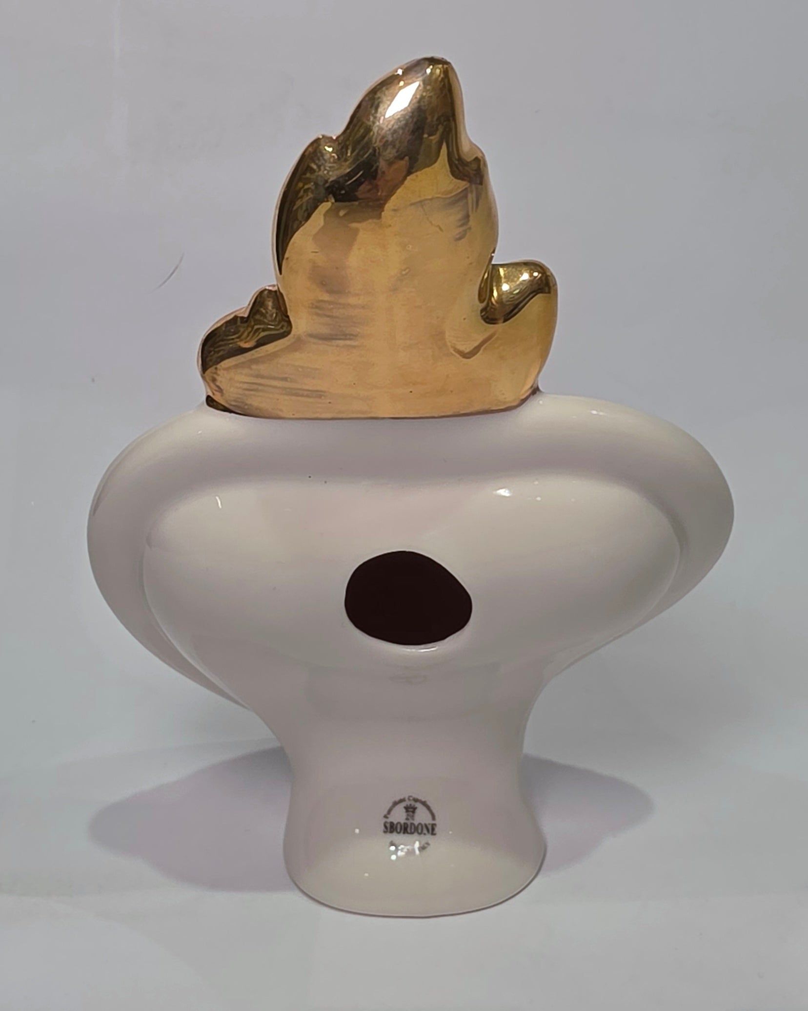 Scultura decorativa a forma di Cuore Sacro in ceramica rossa lucida, caratterizzata dalla scritta "LOVE" in stile pop art bianco e nero al centro del quadrante. L'opera è rifinita con una fiamma superiore dorata e una cornice bianca decorata con borchie oro, perfetta come complemento d'arredo moderno o idea regalo romantica.