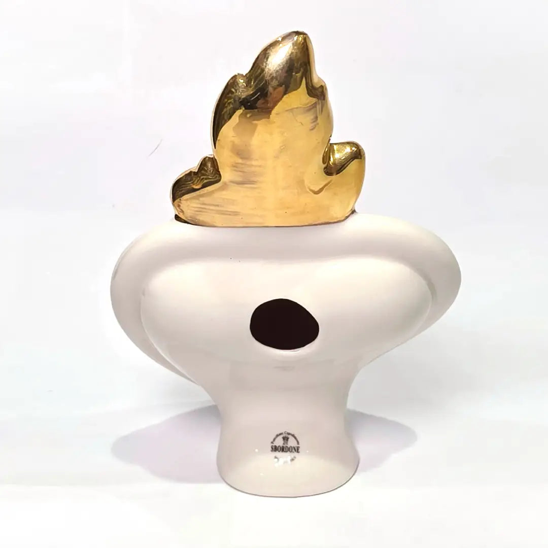 Scultura decorativa a forma di Cuore Sacro in ceramica rossa lucida, caratterizzata dalla scritta "LOVE" in stile pop art bianco e nero al centro del quadrante. L'opera è rifinita con una fiamma superiore dorata e una cornice bianca decorata con borchie oro, perfetta come complemento d'arredo moderno o idea regalo romantica.