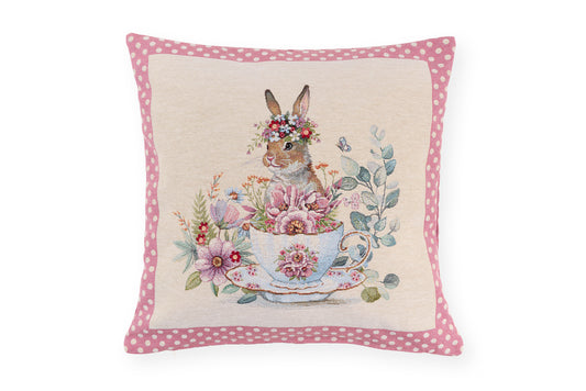 Cuscino pasquale Nuvole di Stoffa i con bordo a pois rosa. Decorazione centrale con illustrazioni vintage di coniglietti, tazze da tè fiorite e ghirlande. Tessuto elegante per la tavola di Pasqua 2026.