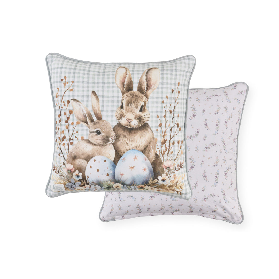 Cuscino pasquale Nuvole di Stoffa in cotone con sfondo celeste a quadretti vichy e retro con cuiricini. Decorazione con illustrazioni di coniglietti, uova colorate e fiori delicati. Elegante tessile per Pasqua 2026.